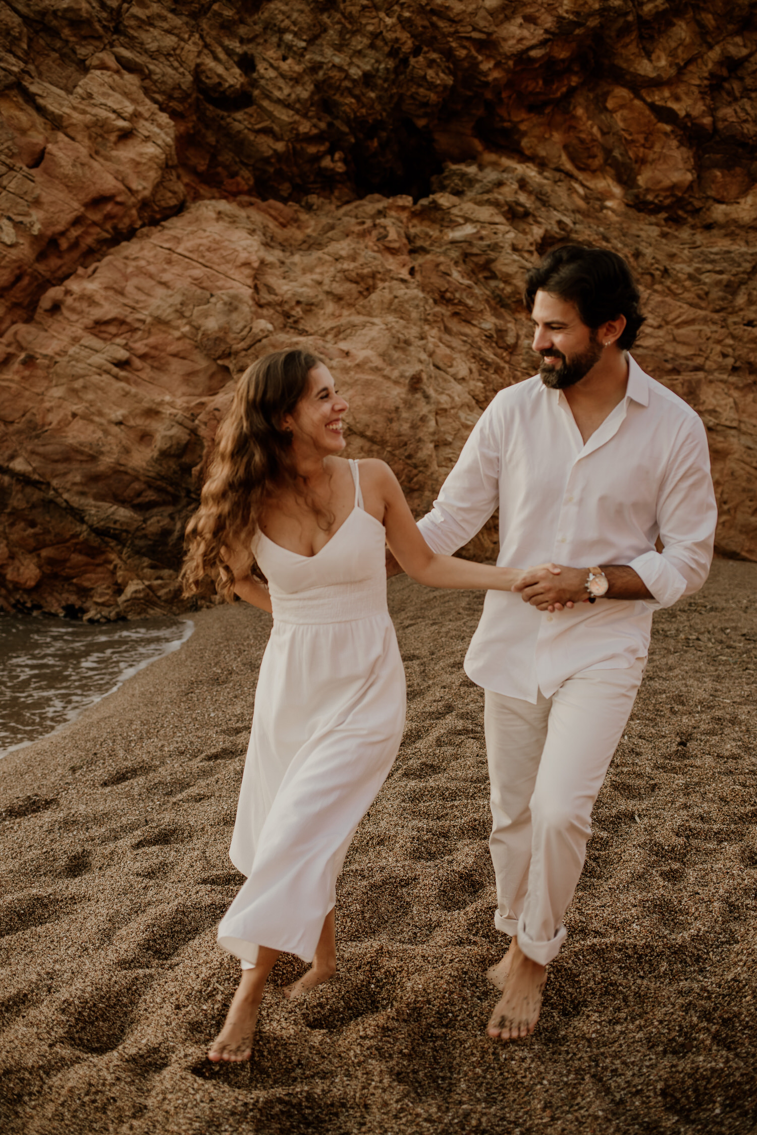 Pareja caminando agarrada de la mano en la playa de Begur Costa Brava, preboda en la Costa brava, Beto Perez fotógrafo de bodas