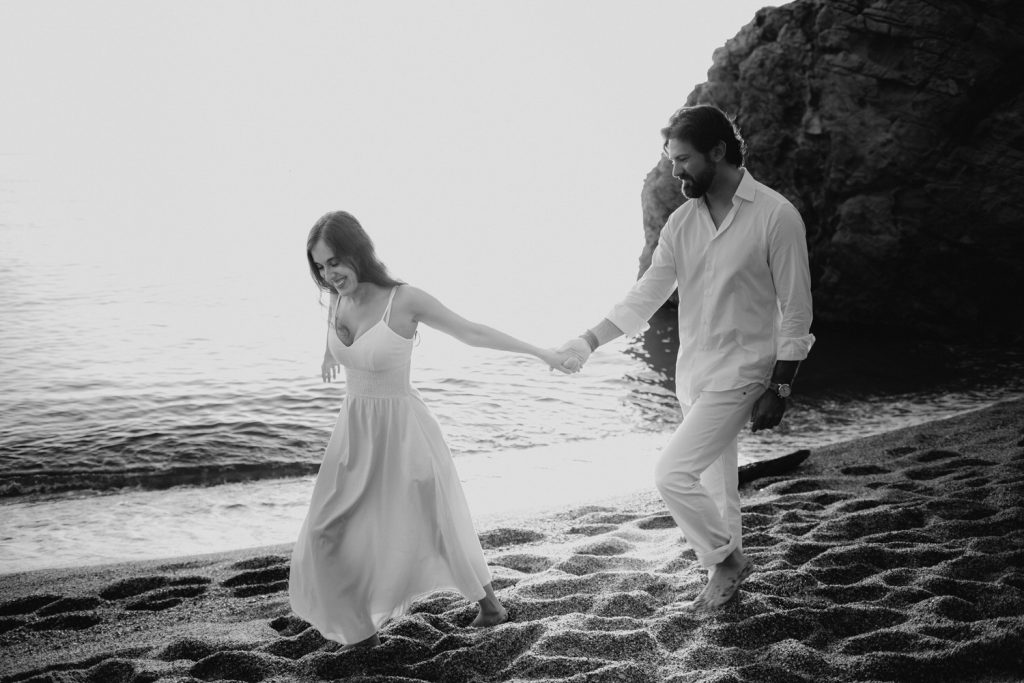 Pareja caminando agarrada de la mano en la playa de Begur Costa Brava, preboda en la Costa brava, Beto Perez fotógrafo de bodas
